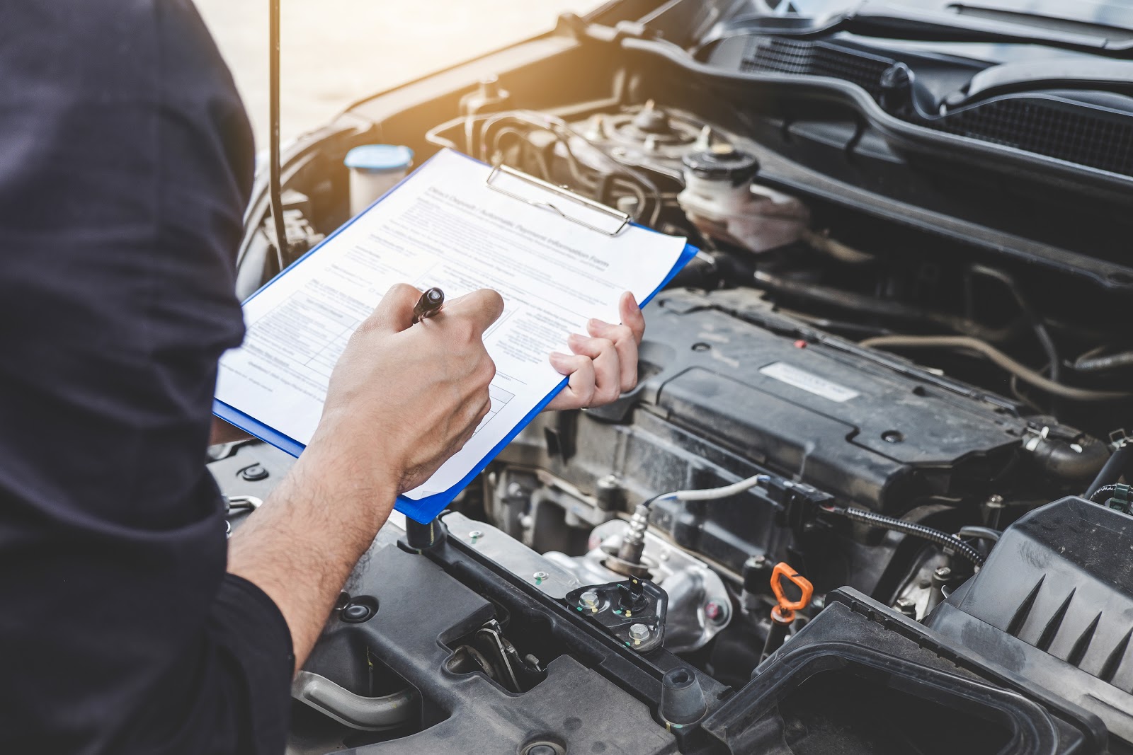 O imagine cu un expert verificând motorul unei mașini.
